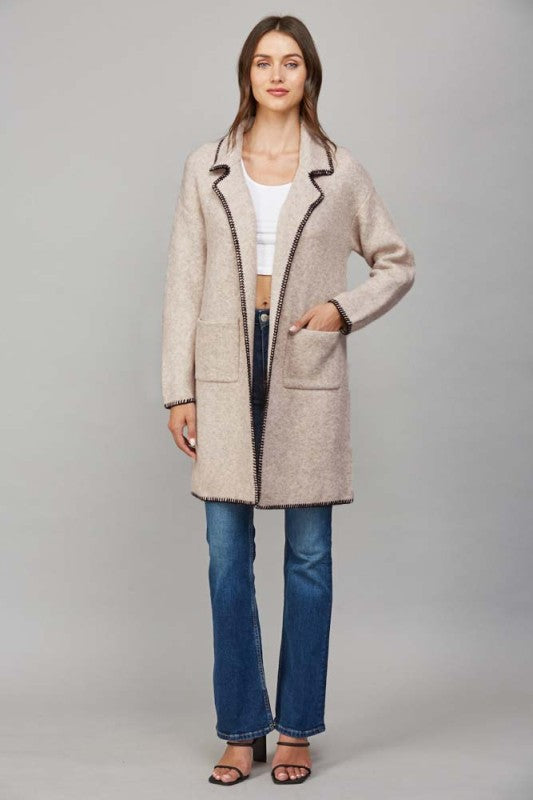 Model wearing contrast whipstitch open cardigan