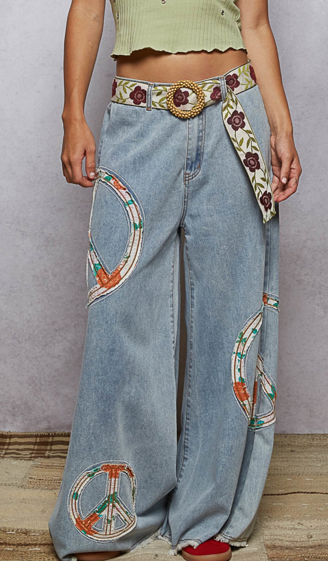 Close-up of boho peace patch detail on wide leg denim pants