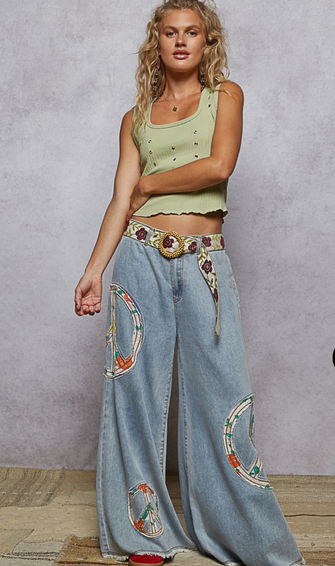 Front view of vintage washed wide leg denim pants with peace patch and elastic waist