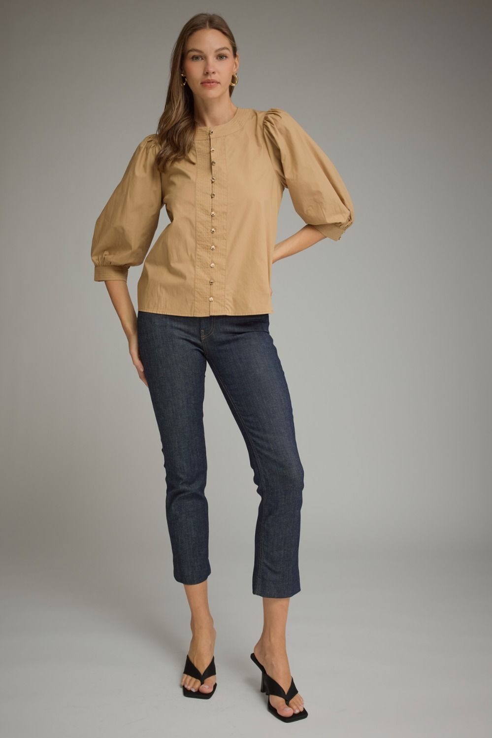 Entro-Solid ¾ balloon sleeve top with a round neckline. Button closure at front. Pintuck detail at neckline, front, and sleeve cuffs. Gathered detail at shoulders and back.