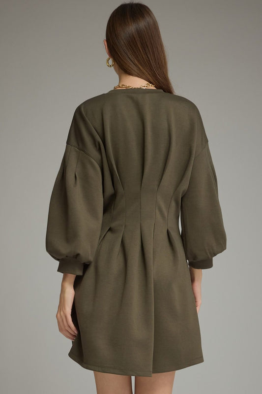 Entro-Solid long sleeve mini dress with a round neckline, pleated waist detail, and side pockets.