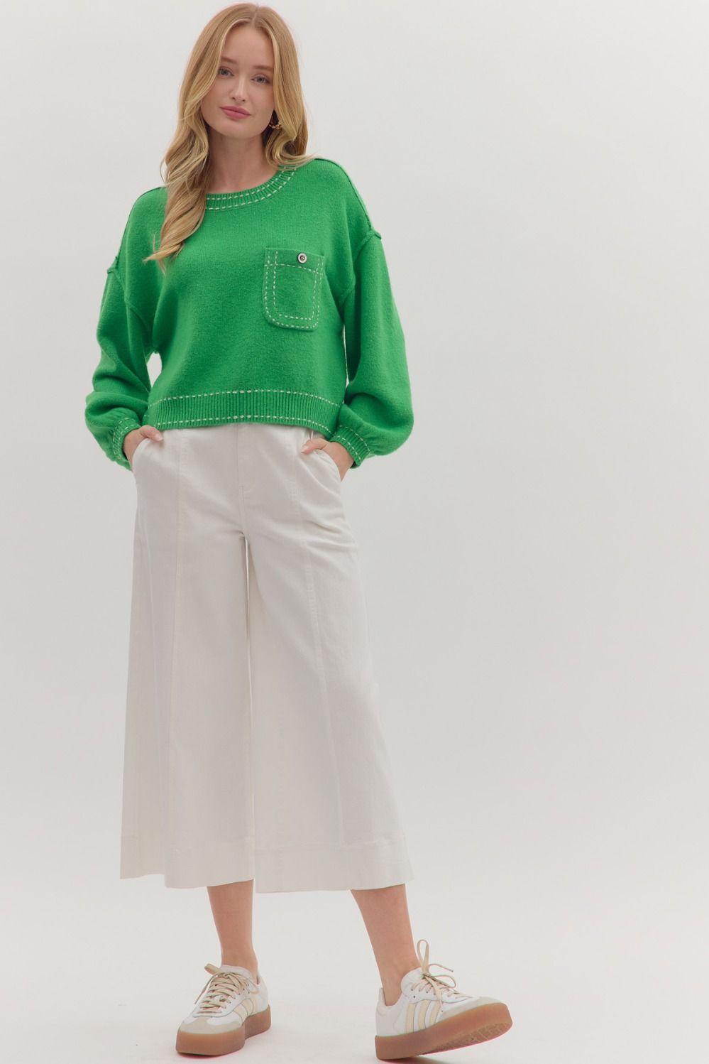 “Model wearing solid long sleeve sweater knit top in red, styled with jeans and and sneakers for a casual fall look.”