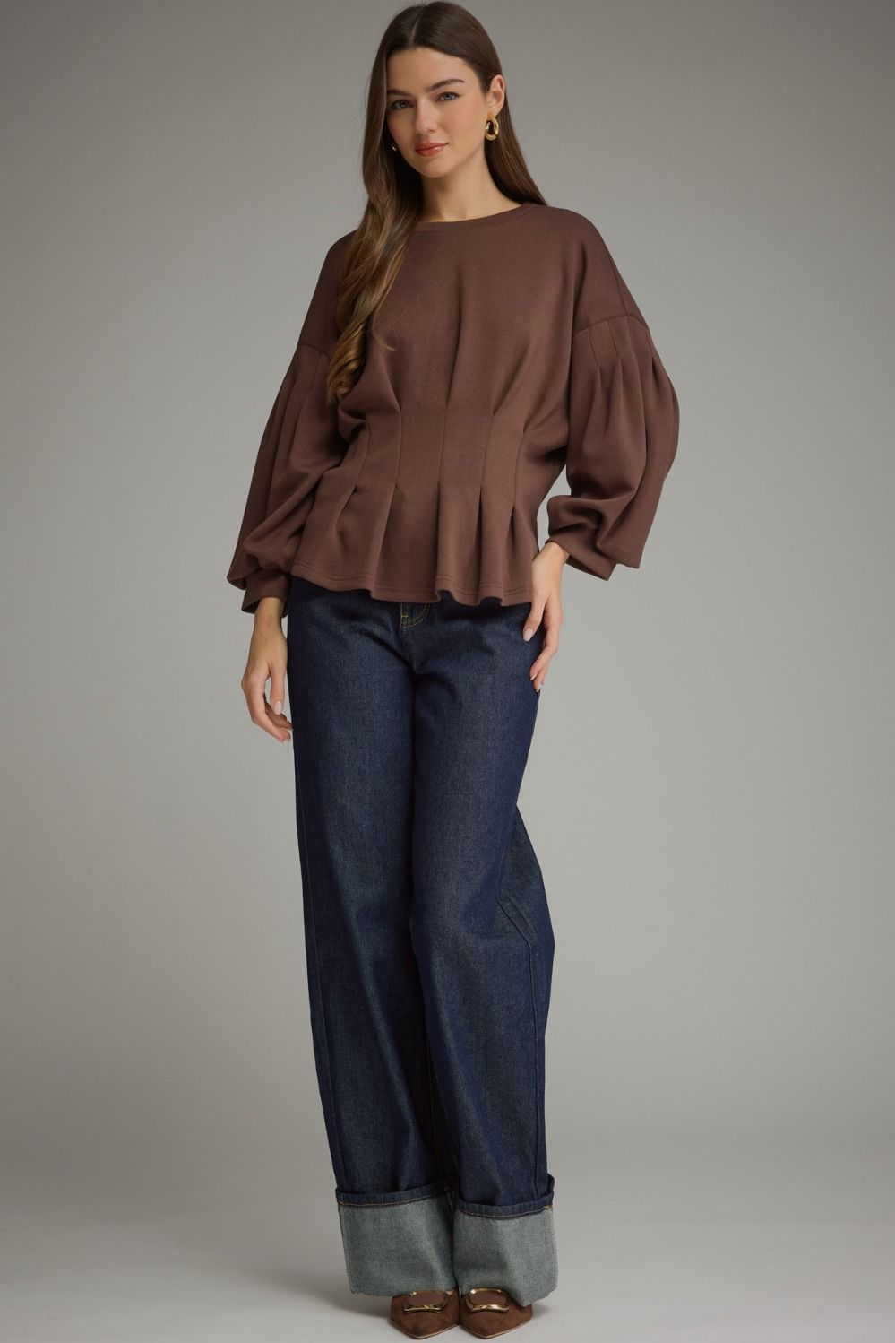 Entro-Solid long balloon sleeve top with a round neckline and pleated detail at waist.