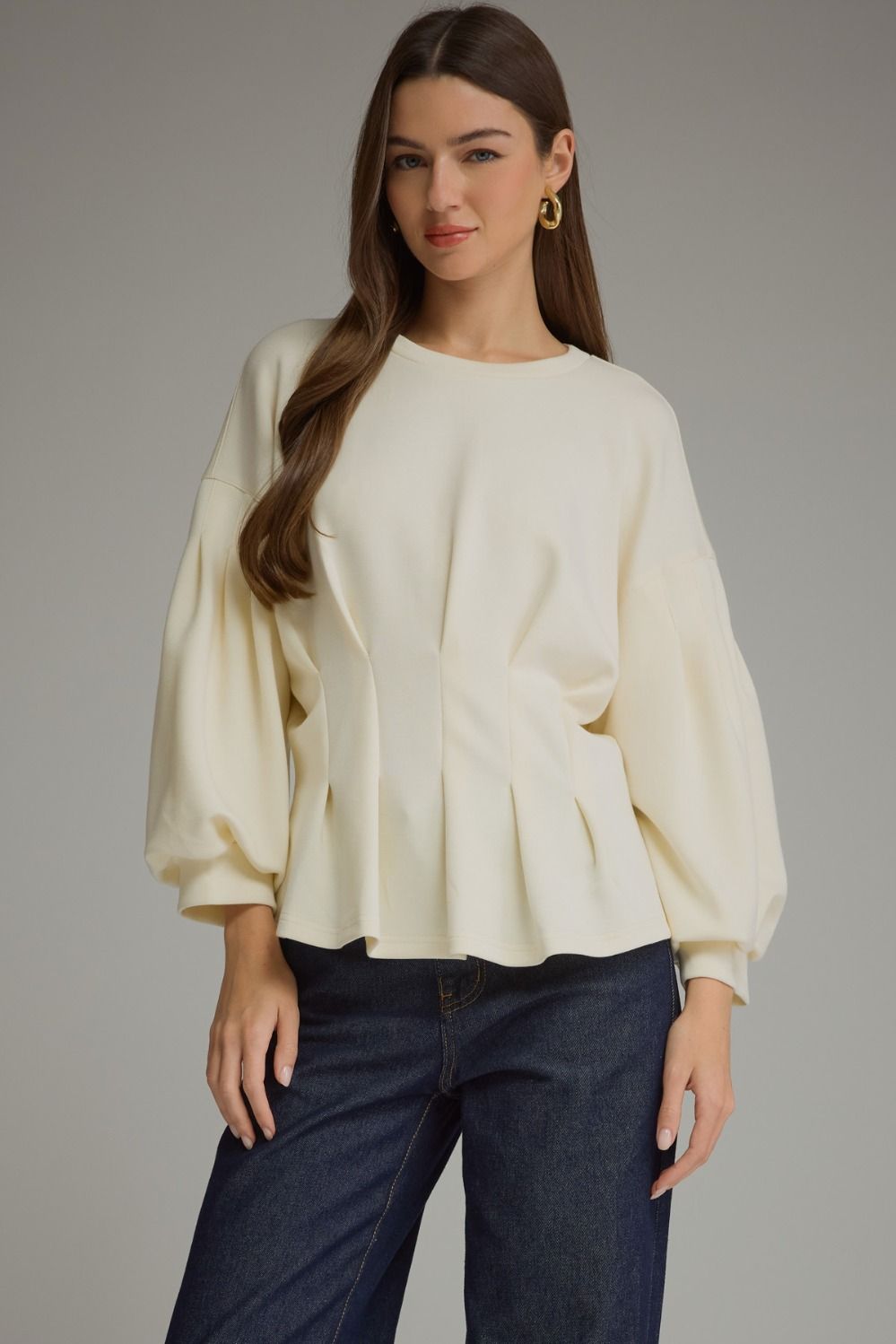 Entro-Solid long balloon sleeve top with a round neckline and pleated detail at waist.