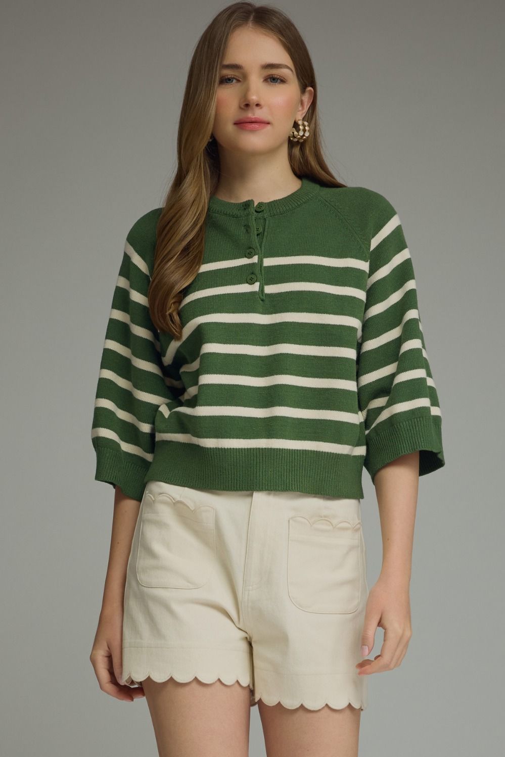 Entro-Stripe ¾ sleeve knit top featuring button closure at front. Ribbed neck band, sleeve cuffs, and hem. Unlined. Knit. Non-sheer. Lightweight.