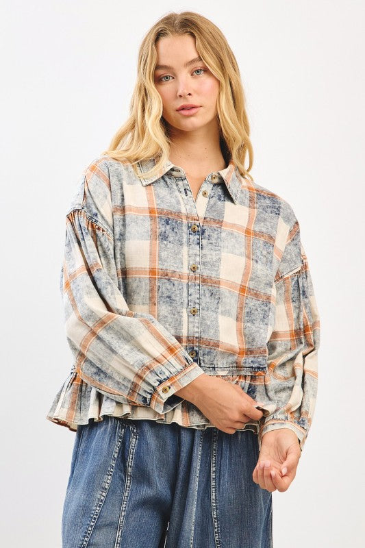 Model wearing plaid flannel blouse with balloon sleeves and button cuffs