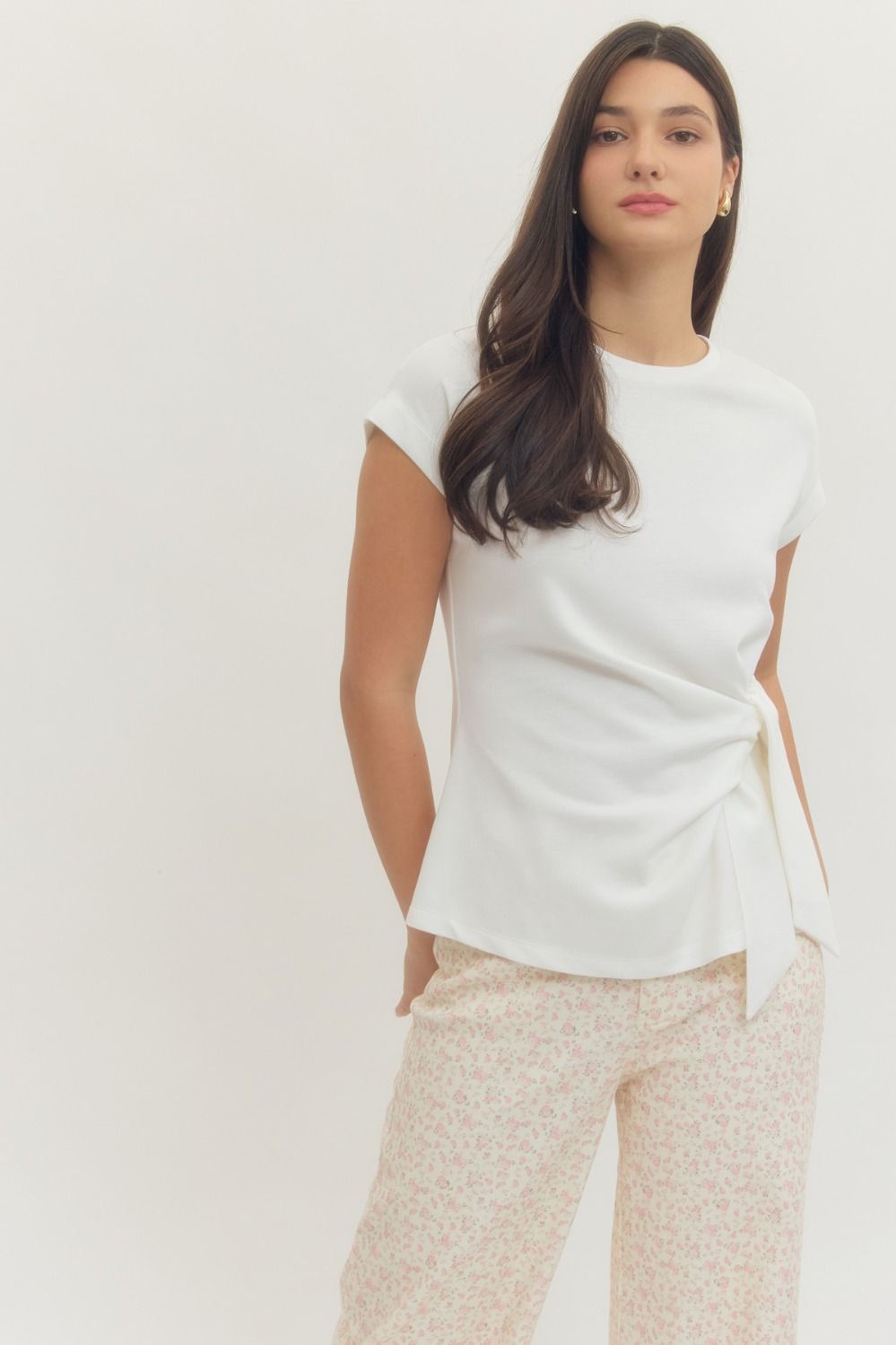 Entro Solid short-sleeve top featuring side self-tie bow detail at waist and round neck. Unlined. Knit. Non-sheer. Lightweight.