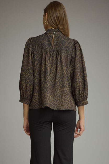 Entro-Animal print ¾ balloon sleeve top with a ruffle stand collar. Ruffle trim detail at front. Back keyhole with button closure. Gathered detail at back.