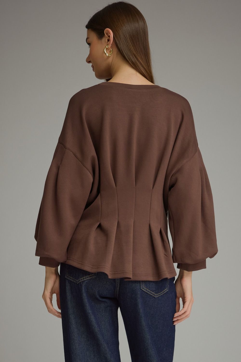 Entro-Solid long balloon sleeve top with a round neckline and pleated detail at waist.