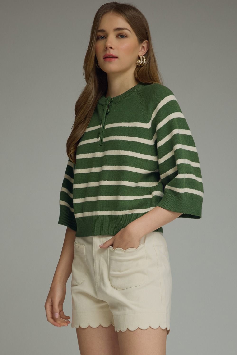 Entro-Stripe ¾ sleeve knit top featuring button closure at front. Ribbed neck band, sleeve cuffs, and hem. Unlined. Knit. Non-sheer. Lightweight.