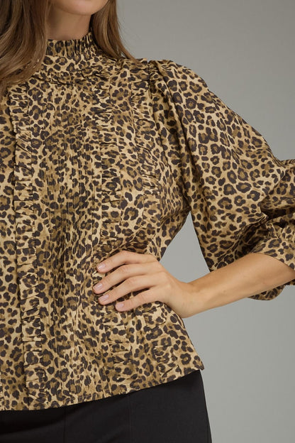 Entro-Animal print ¾ balloon sleeve top with a ruffle stand collar. Ruffle trim detail at front. Back keyhole with button closure. Gathered detail at back.