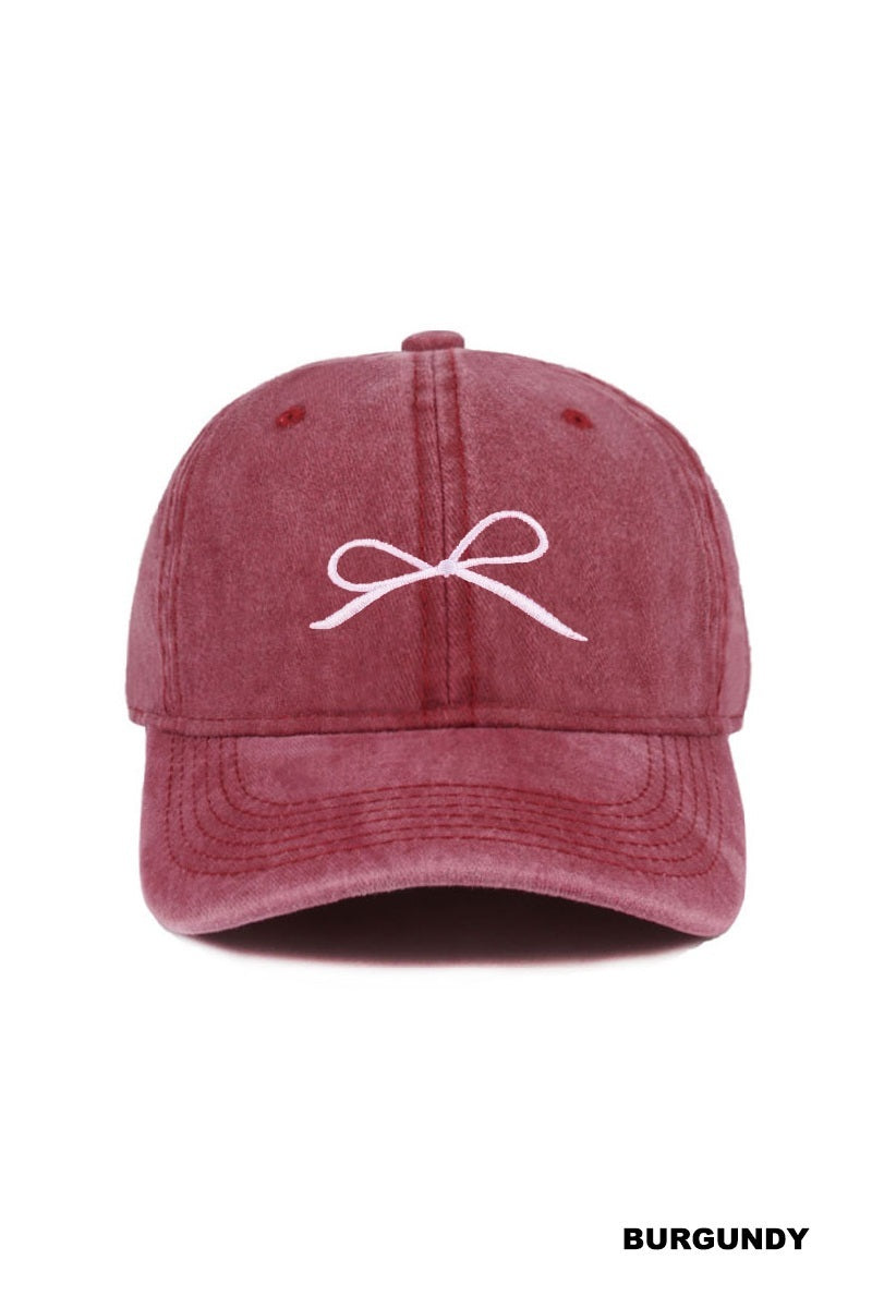Burgundy cap with a white bow design on a white background