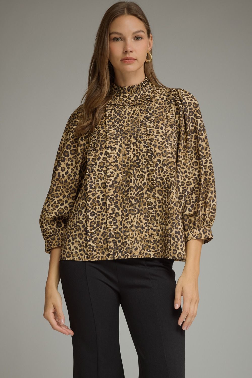 Entro-Animal print ¾ balloon sleeve top with a ruffle stand collar. Ruffle trim detail at front. Back keyhole with button closure. Gathered detail at back.