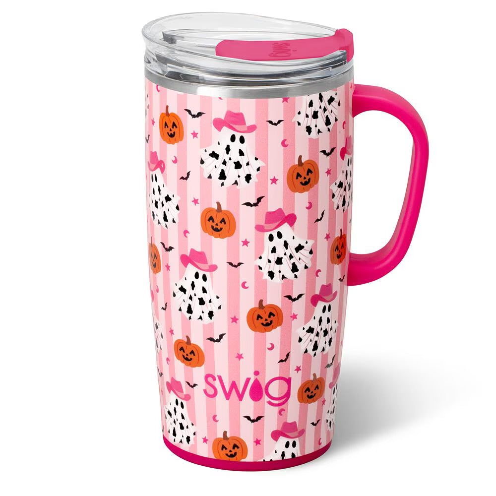 A pink and white striped insulated travel tumbler with a bright pink handle and lid, decorated with cartoon pumpkins And cow print ghosts. The brand name 'swig' is printed near the bottom.
