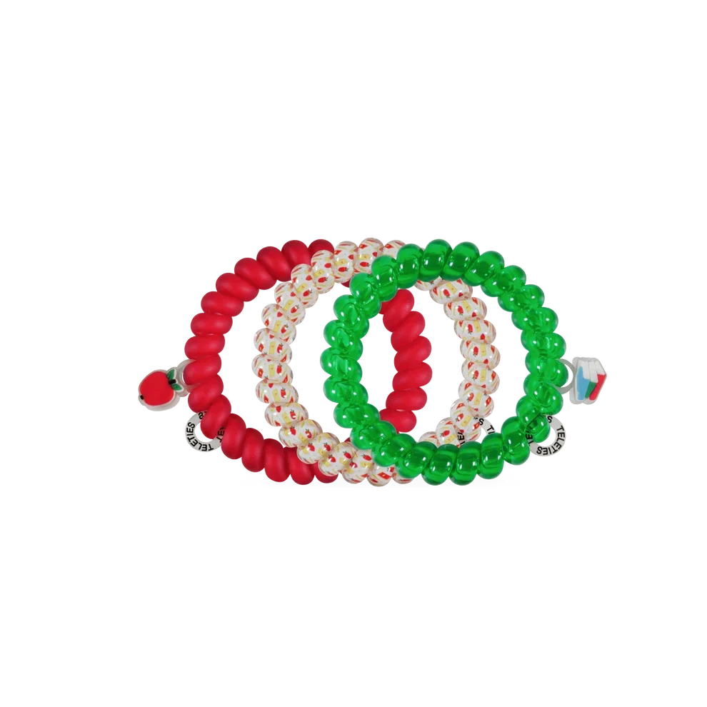 Three beaded stretch hair ties arranged in a circle on a plain white background. One bracelet is solid red, one is translucent white with tiny red and green dots, and one is solid green.