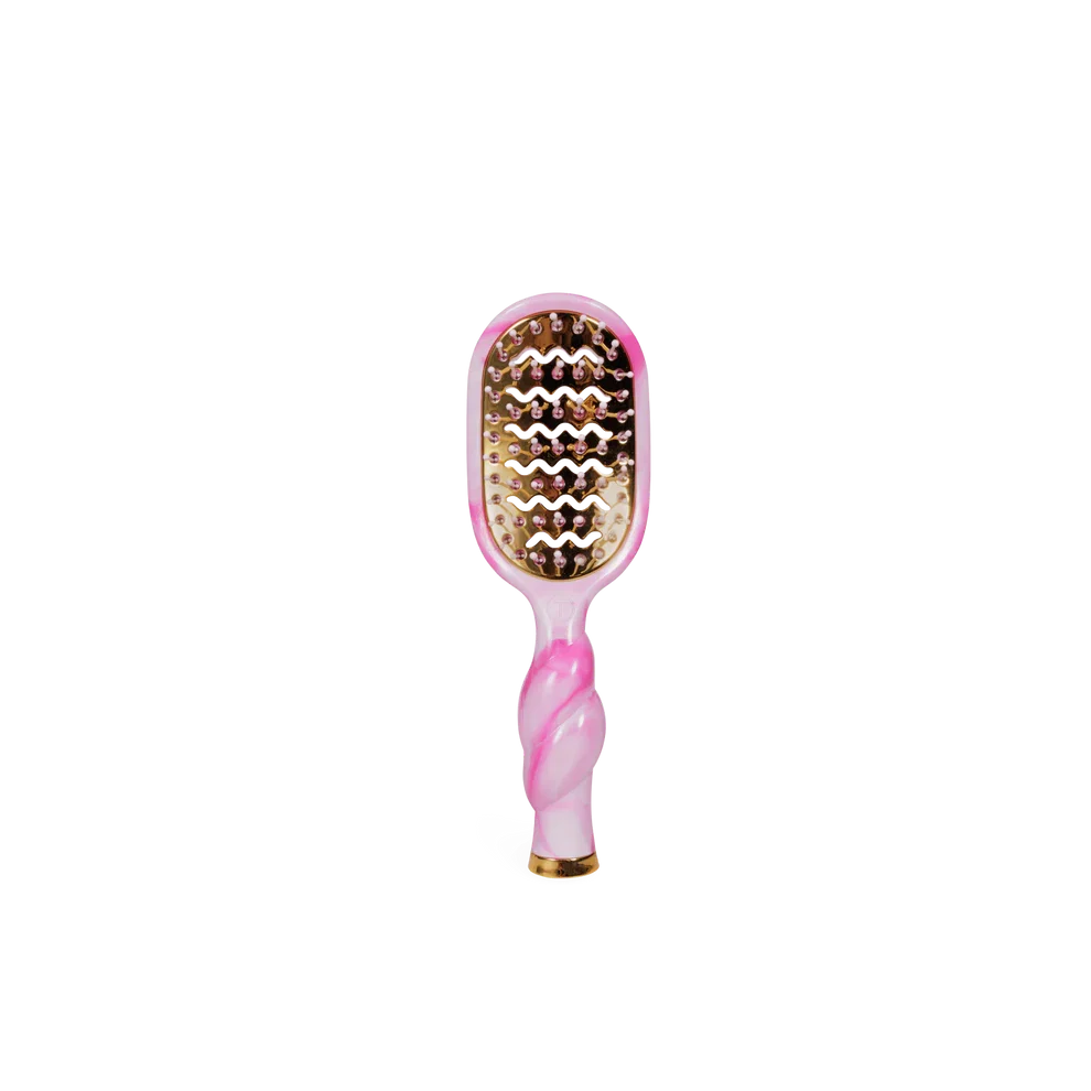 Pink and gold hairbrush on a white background