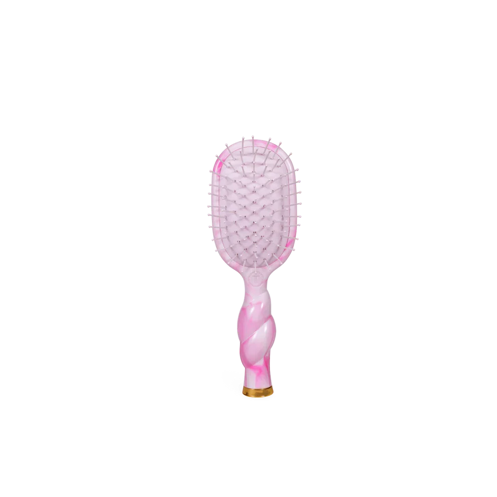 Pink and gold hairbrush on a white background