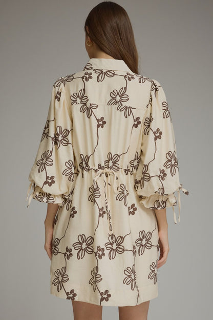 Entro-Floral ¾ balloon sleeve mini dress featuring a split neckline and adjustable tie cuffs. Drawstring waist at back. Side pockets.