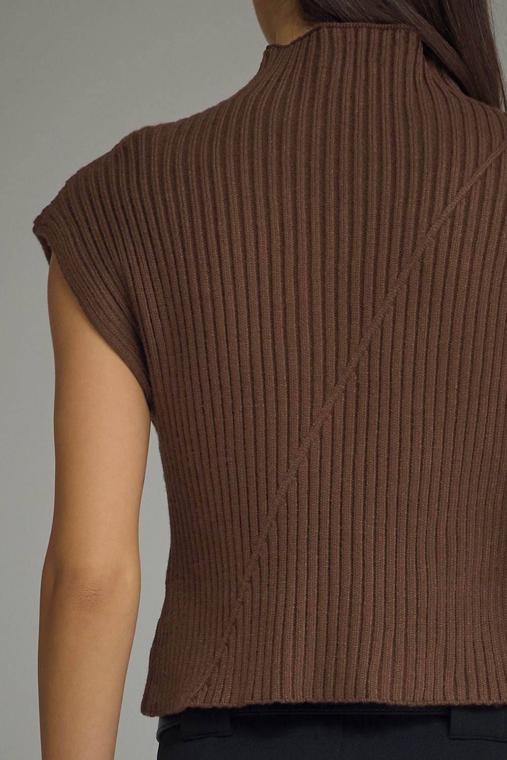 Entro-Solid cap sleeve knit top featuring ribbed texture. Mock neckline. Diagonal seam detail at front and back.