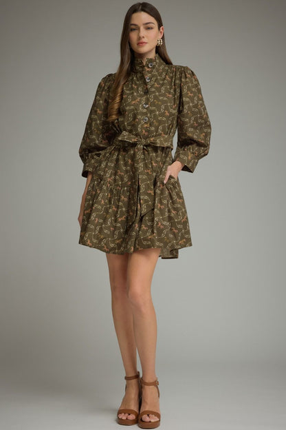 Entro-Horse print ¾ puff sleeve mini dress with a shirt collar and button closure at front. Self-tie belt at waist. Button cuffs. Tiered skirt. Side pockets.