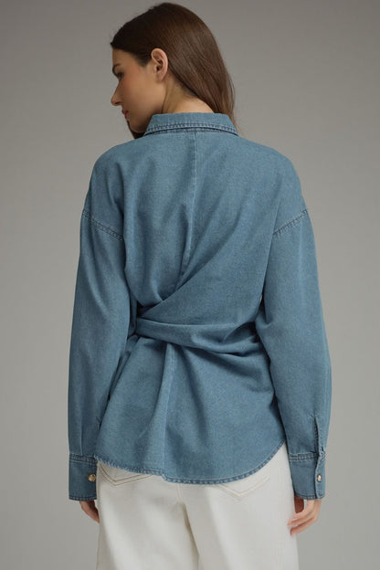 Entro-Solid denim long sleeve top featuring button closure at front and a wraparound self-tie detail. Button cuffs.