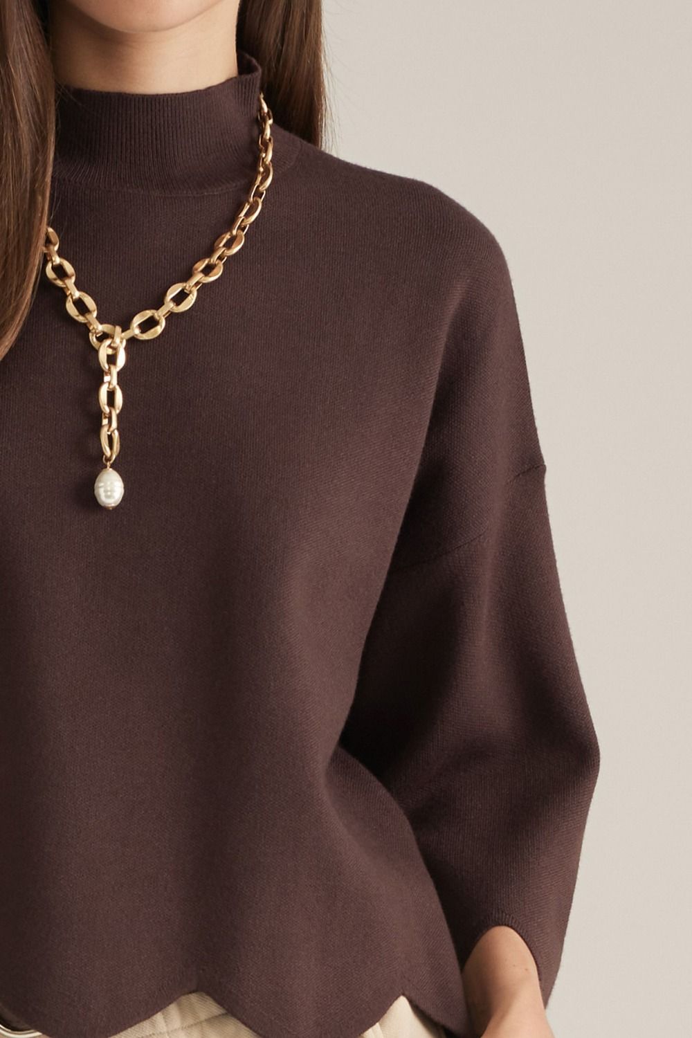 Entro-Solid ¾ sleeve sweater top with a mock neck. Scalloped hem and sleeve edges.