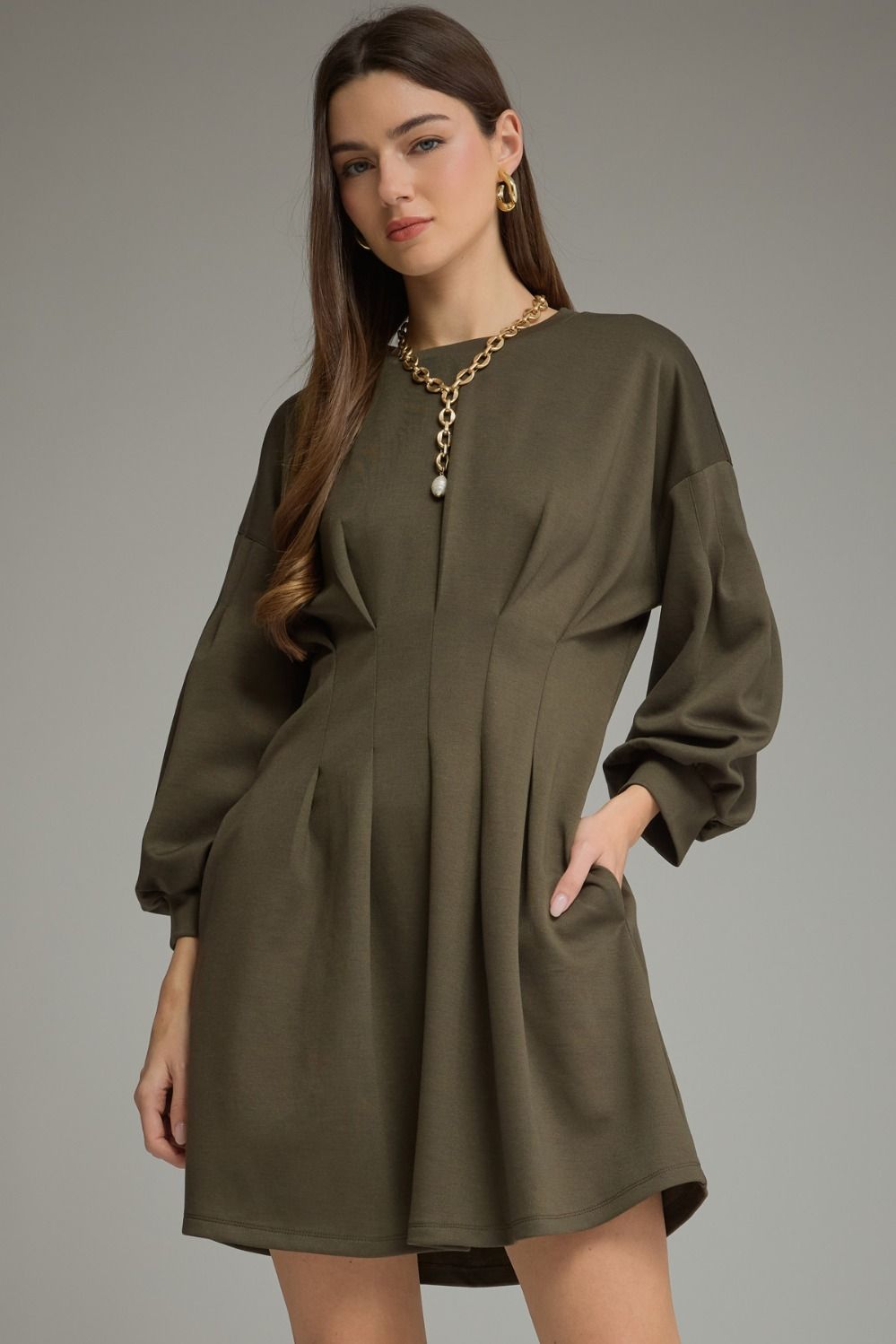 Entro-Solid long sleeve mini dress with a round neckline, pleated waist detail, and side pockets.