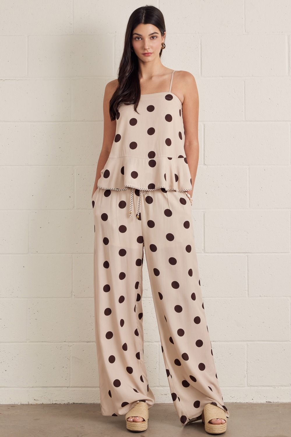 Entro-Polka dot sleeveless peplum top featuring square neckline. Self-tie bow detail at back. Adjustable straps. with wide leg pants