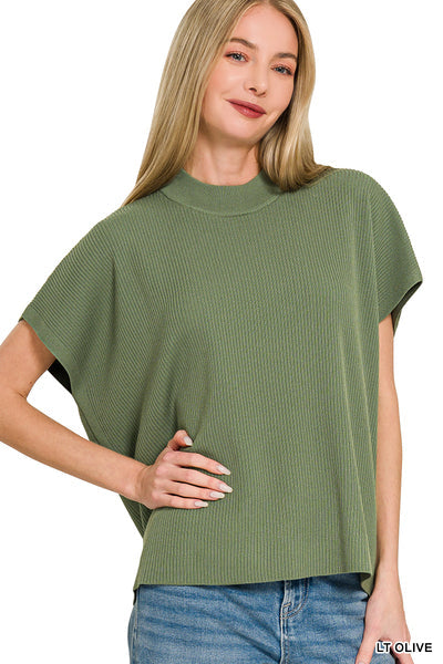 Woman wearing a green ribbed sweater with short sleeves on a white background
