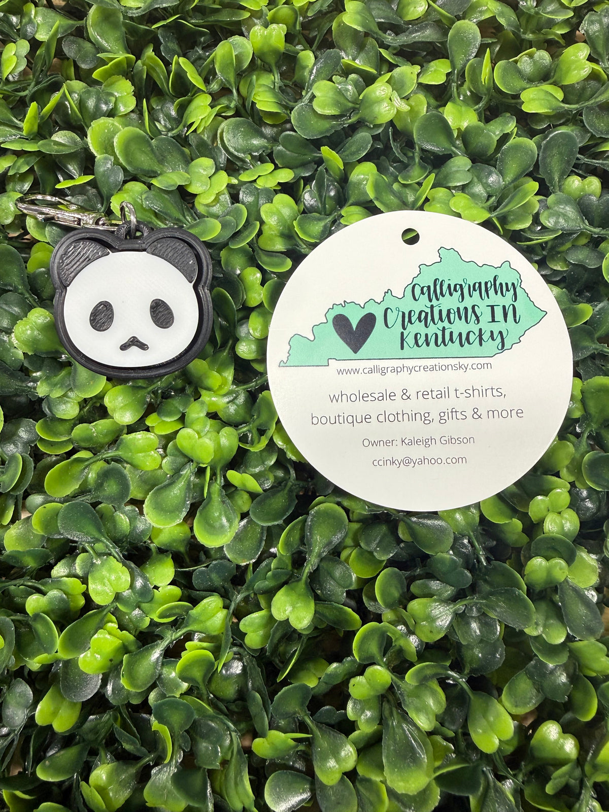 Keychain with panda design on a green leafy background