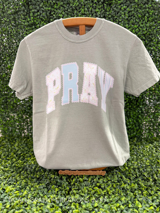 sage green shirt with pray with lace printed details on a wooden stand 
