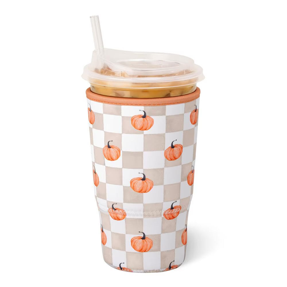 A tall insulated tumbler with a clear lid and straw, featuring an orange pumpkin pattern on a beige and white checkerboard design, shown on a white background.