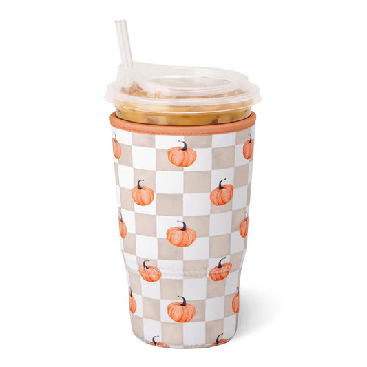 A tall insulated tumbler with a clear lid and straw, featuring an orange pumpkin pattern on a beige and white checkerboard design, shown on a white background.