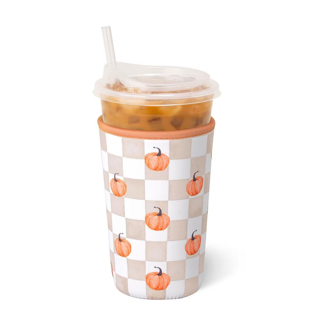 A Pumpkin Check Medium Swig Iced Cup Coolie wrapped in a beige and white checkered sleeve decorated with small orange pumpkins, on a white background.