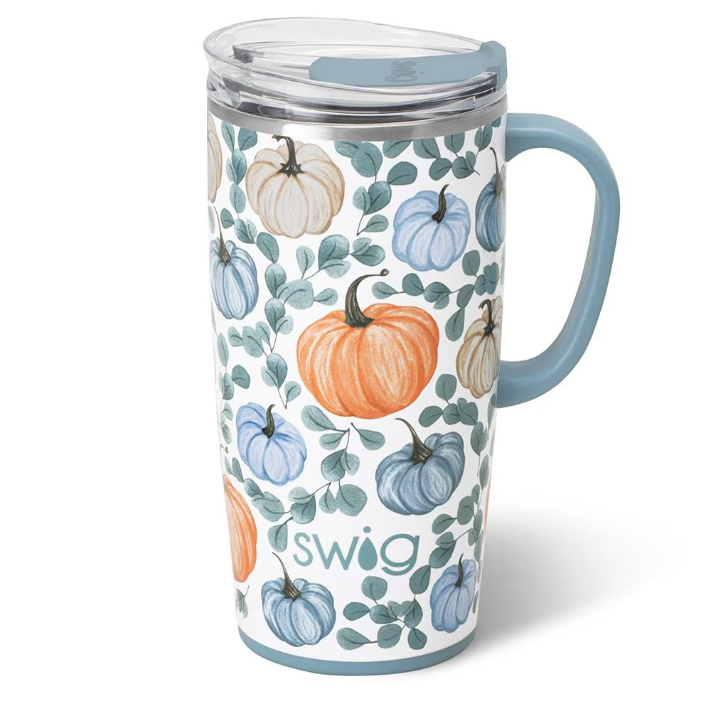 A tall insulated travel tumbler with a clear lid and light blue handle and base, decorated with a pattern of orange, blue, and cream pumpkins and green leaves. The word 'swig' is printed near the bottom.