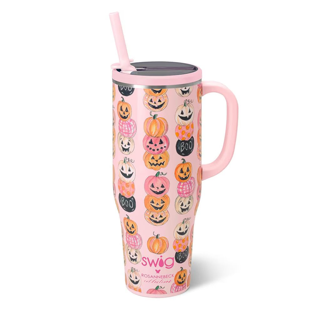 A pink handled travel tumbler with a lid and straw, decorated with a repeating pattern of orange, black, and white jack-o'-lanterns and the words 'swoo Halloween' near the bottom, shown on a white background.