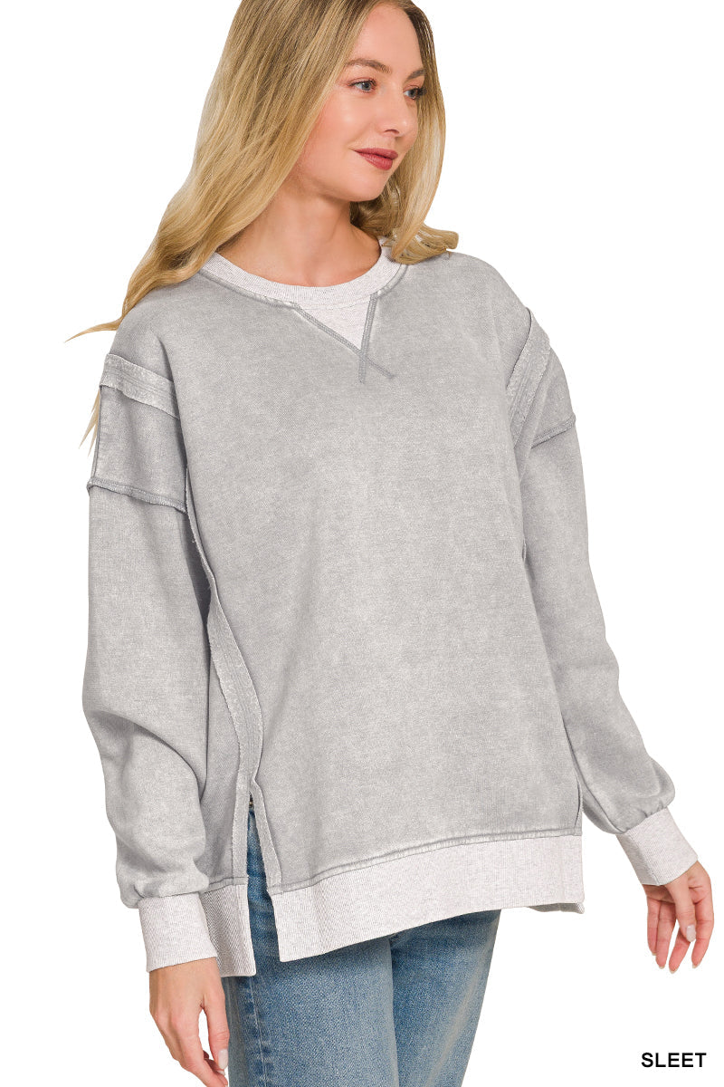Woman wearing a gray oversized sweatshirt with a white trim on a white background