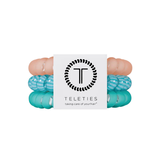 Set of three hair ties that are coral, green and striped. 