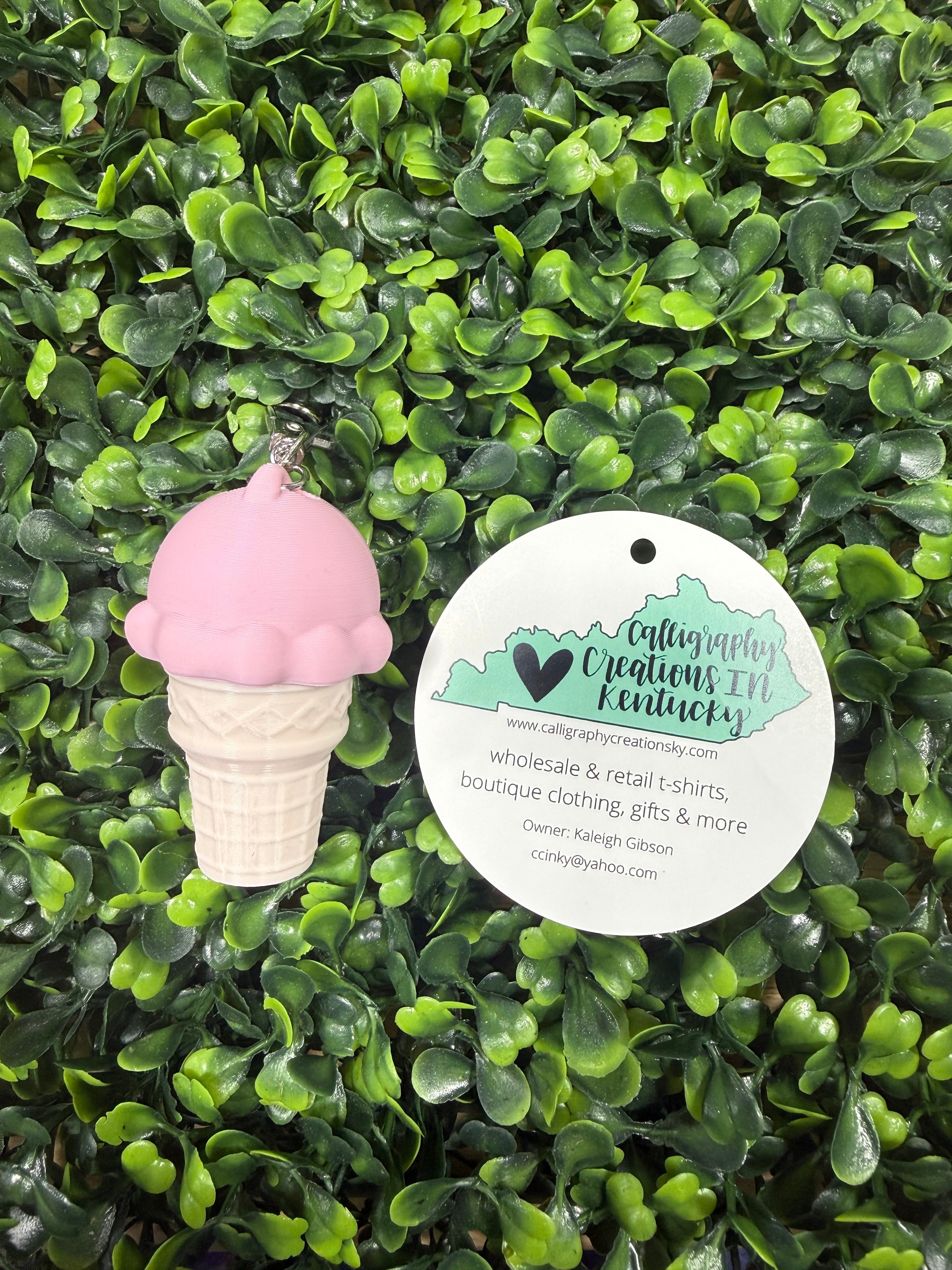 Strawberry ice cream key chain on a green leafy background 