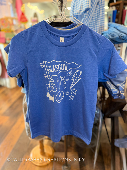 A blue short-sleeve graphic t-shirt hanging on a metal hanger in a retail store. The shirt features a white line-art graphic of a Glasgow flag, cherries, a party hat, stars, and the word 'GLASCOW'.