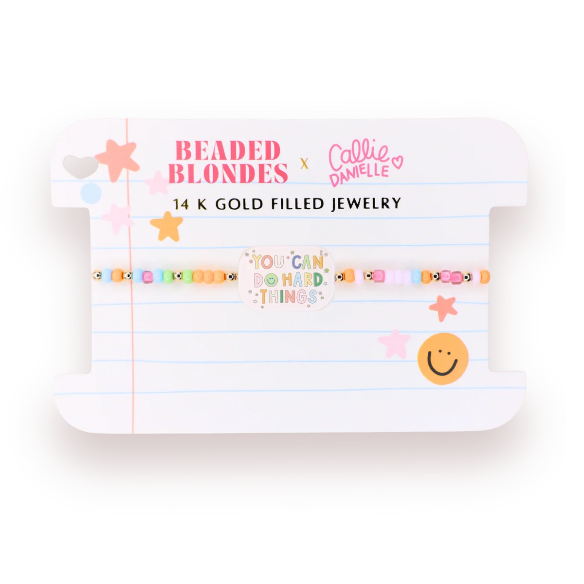 A beaded bracelet displayed on a white card backing. The bracelet features pastel-colored beads with small gold-toned fish details and is flanked by gold star-shaped embellishments.