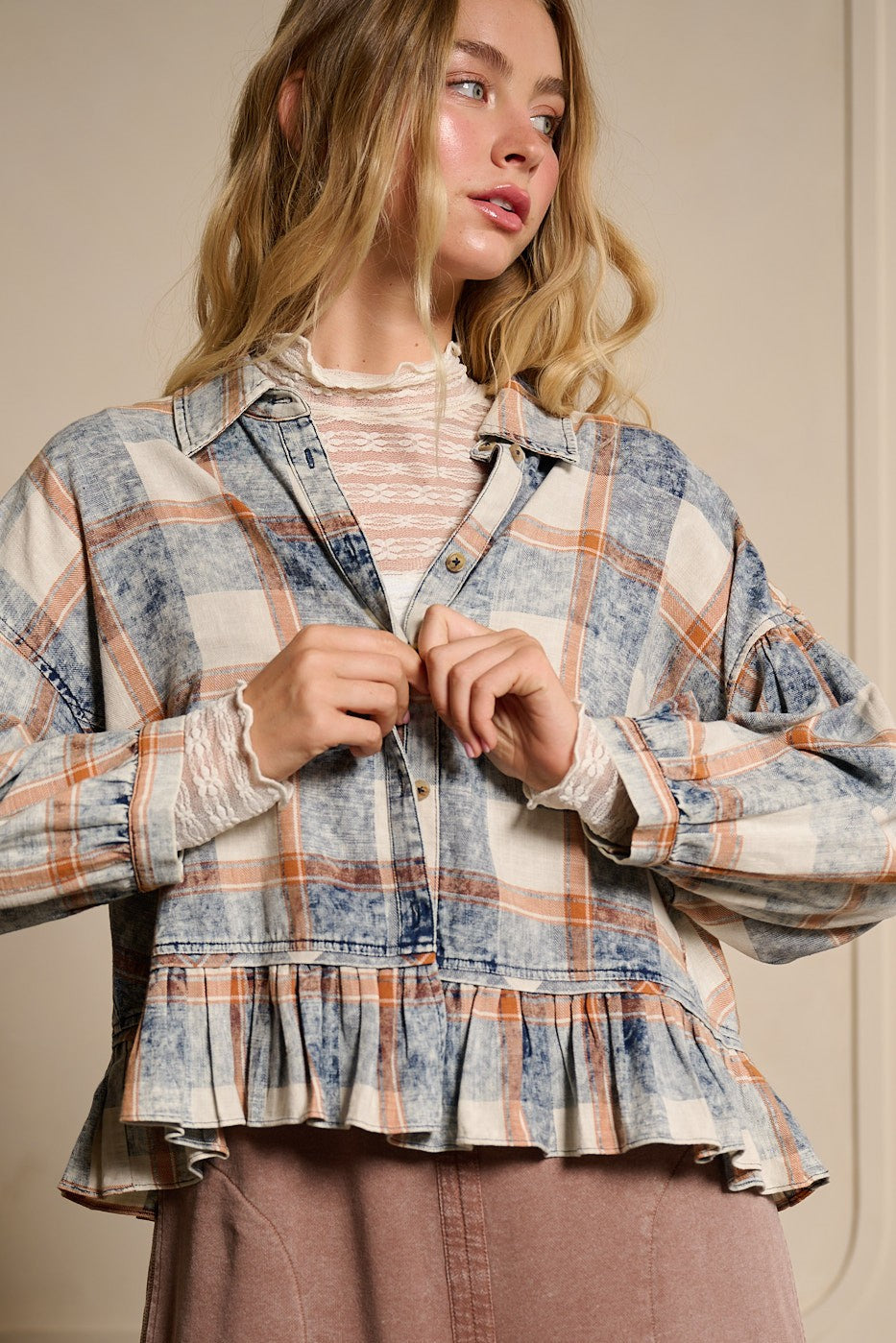 Front view of washed plaid peplum button-down top with collar and ruffle hem