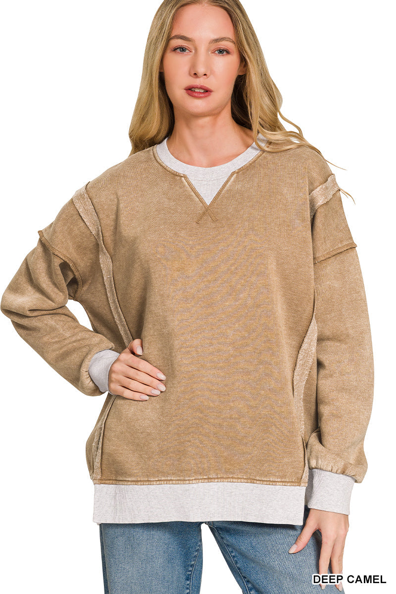 Woman wearing a beige sweater with white trim on a white background