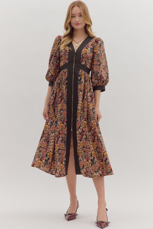 A paisley print midi dress with puff sleeves, striped trim, and a partial front zipper closure. The lightweight, woven fabric drapes beautifully, showcasing the dress’s flattering silhouette
