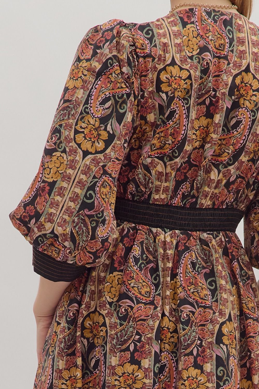The back of the dress, displaying the elegant paisley print and the puff sleeve detail.