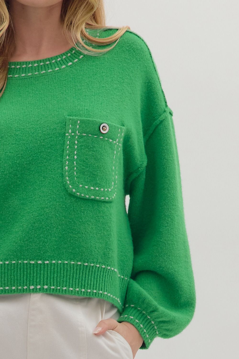 Solid long sleeve sweater knit top with contrast blanket stitch accents and button chest pocket. Medium-weight knit fabric. Available in red.”